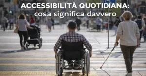 Persona in carrozzina attraversa la strada in un contesto urbano inclusivo, esempio di accessibilità quotidiana.